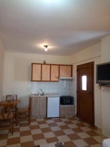 a kitchen with a checkered floor and a white refrigerator at Nikos's apartment in Taxiarchis