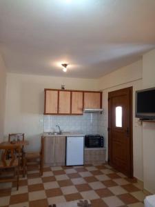 Kuchnia z podłogą wyłożoną szachownicą i białą lodówką w obiekcie Nikos's apartment w mieście Taxiarchis