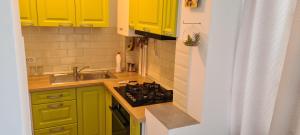 a small kitchen with yellow cabinets and a sink at Apartament cu 1 camera spatios ,luminos . in Cugir