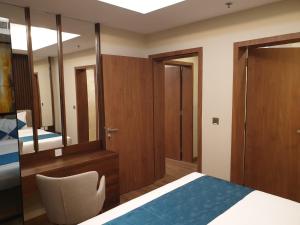 a bedroom with a bed and a mirror at Terminal Inn Fully Furnished Hotel & Apartment- Al Mansoura in Doha
