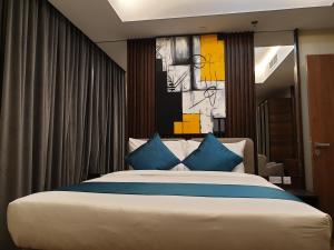 sypialnia z dużym łóżkiem z niebieskimi poduszkami w obiekcie Terminal Inn Al Mansoura w mieście Doha