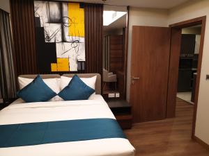 a bedroom with a large bed with blue pillows at Terminal Inn Fully Furnished Hotel & Apartment- Al Mansoura in Doha