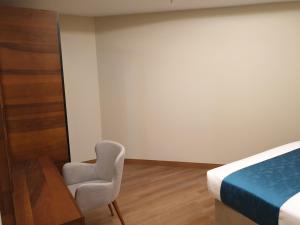 a bedroom with a bed and a desk and a chair at Terminal Inn Fully Furnished Hotel & Apartment- Al Mansoura in Doha
