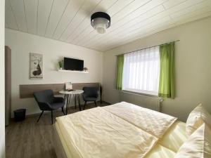 a bedroom with a bed and a table with chairs at Landgasthof Kanz in Tanna +24 photos