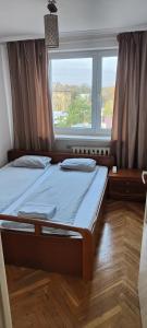 a bedroom with two beds in front of a window at Apartament Jarosław na wyłączność in Jarosław