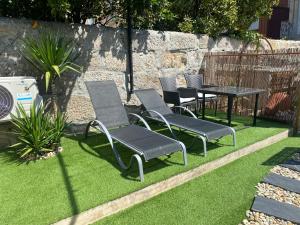 a group of chairs and a table on some grass at GuestHouse Marquês in Porto