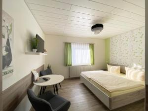 1 dormitorio con 1 cama, mesa y sillas en Landgasthof Kanz, en Tanna