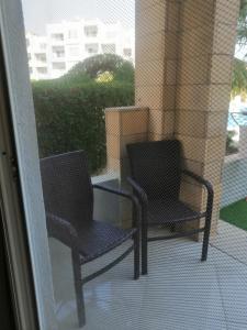 two chairs sitting on the porch of a balcony at Aqua marine - comfort vacation home with pool view in Sharm El Sheikh