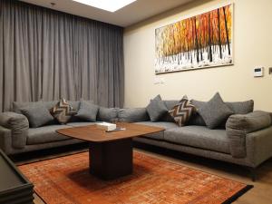 a living room with a couch and a table at Terminal Inn Fully Furnished Hotel & Apartment- Al Mansoura in Doha
