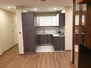 a large kitchen with a sink and a counter top at Terminal Inn Fully Furnished Hotel & Apartment- Al Mansoura in Doha