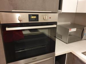 a oven with a clock on it in a kitchen at Terminal Inn Fully Furnished Hotel & Apartment- Al Mansoura in Doha