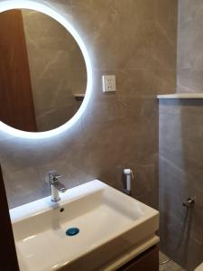 a bathroom with a white sink and a mirror at Terminal Inn Fully Furnished Hotel & Apartment- Al Mansoura in Doha