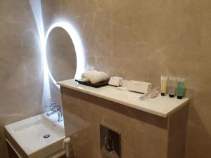 a bathroom with a sink and a mirror at Terminal Inn Fully Furnished Hotel & Apartment- Al Mansoura in Doha