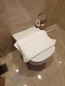 a bathroom with a toilet with a blanket on it at Terminal Inn Fully Furnished Hotel & Apartment- Al Mansoura in Doha