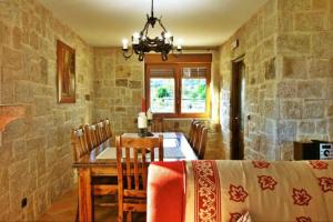 uma sala de jantar com uma mesa e uma parede de pedra em Casa Os Castelos em Monteviján