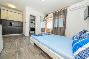 ein Schlafzimmer mit einem großen Bett mit blauen Kissen in der Unterkunft Apartmani Por in Vir