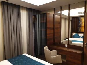 a bedroom with a bed and a desk and a mirror at Terminal Inn Fully Furnished Hotel & Apartment- Al Mansoura in Doha