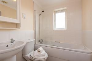 a white bathroom with a sink and a toilet and a tub at Hillbrook in Thornaby on Tees +30 photos