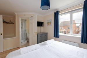 a bedroom with a white bed and a window at Hillbrook in Thornaby on Tees