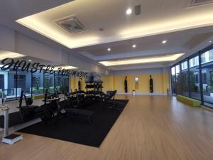 een fitnessruimte met loopbanden en stoelen in een kamer bij Cozy Loft By Hauzcinta @Sunway Grid in Kampong Pendas