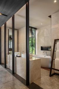 a bathroom with a tub and a sink and a bath tub at Madifushi Private Island in Meemu Atoll