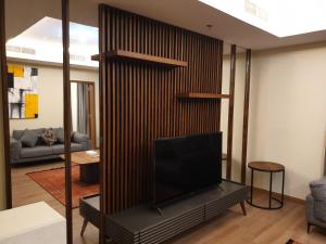 a living room with a tv on a wall at Terminal Inn Fully Furnished Hotel & Apartment- Al Mansoura in Doha