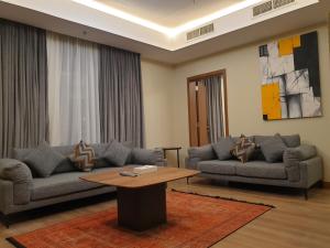 a living room with two couches and a coffee table at Terminal Inn Fully Furnished Hotel & Apartment- Al Mansoura in Doha