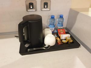 a coffee maker on a shelf in a kitchen at Terminal Inn Fully Furnished Hotel & Apartment- Al Mansoura in Doha