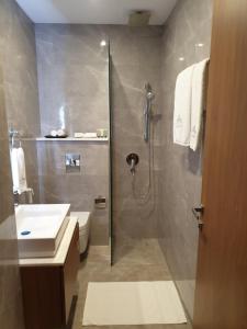 a bathroom with a shower and a toilet and a sink at Terminal Inn Fully Furnished Hotel & Apartment- Al Mansoura in Doha