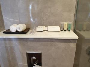 a shelf in a bathroom with towels on it at Terminal Inn Fully Furnished Hotel & Apartment- Al Mansoura in Doha