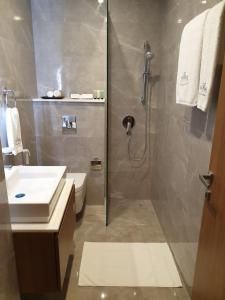 a bathroom with a shower and a toilet and a sink at Terminal Inn Fully Furnished Hotel & Apartment- Al Mansoura in Doha
