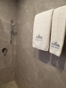 a bathroom with two towels hanging on a shower at Terminal Inn Fully Furnished Hotel & Apartment- Al Mansoura in Doha