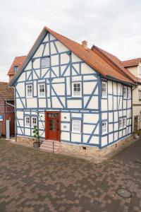 un edificio azul y blanco con una puerta roja en BACCO Bed & Breakfast, en Rotenburg an der Fulda