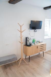 a living room with a tv and a wooden dresser at BACCO Bed & Breakfast in Rotenburg an der Fulda