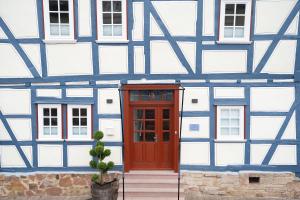 a blue and white building with a red door at BACCO Bed & Breakfast in Rotenburg an der Fulda