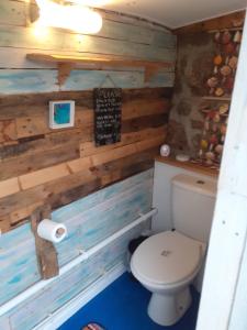 a bathroom with a toilet and a sign on the wall at Little Pedn in Penzance