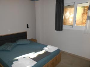 SPΛCES PYLOS Apartments في بيلوس: غرفة نوم عليها سرير وفوط