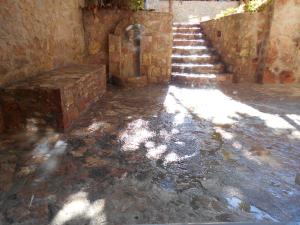 Une allée avec des marches en pierre et un bâtiment en pierre dans l'établissement SPΛCES PYLOS Apartments, à Pylos