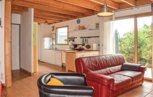 a living room with a leather couch and a kitchen at Nice Home In Plounéour-Trez With Sauna in Plounéour-Trez