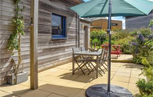 a patio with a table and an umbrella at Nice Home In Plounéour-Trez With Sauna in Plounéour-Trez +27 photos