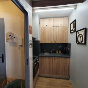 a kitchen with wooden cabinets and a door open at Studio Hyper centre Valberg in Valberg