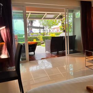 a living room with glass doors and a dining room at Mama Beach Residence - Adults Only in Phi Phi Don