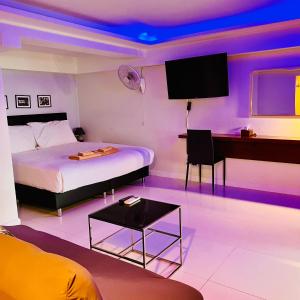 um quarto com uma cama, uma secretária e uma televisão em Mama Beach Residence - Adults Only em Phi Phi Don