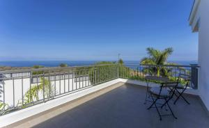ein Balkon mit Tisch und Stühlen und dem Meer in der Unterkunft Luxury Villa Atlante con piscina climatiza privada in Santa Úrsula