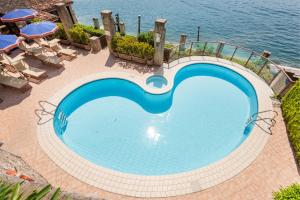 a large swimming pool next to the water at Hotel Le Palme in Limone sul Garda