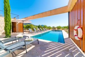 uma piscina com espreguiçadeiras e um guarda-sol em Ideal Property Mallorca - Sa Vinyeta em Selva