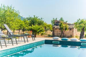 uma piscina com uma cadeira e uma mesa ao lado de uma casa em Ideal Property Mallorca - Sa Vinyeta em Selva