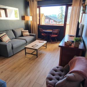 a living room with a couch and a table at Studio Hyper centre Valberg in Valberg