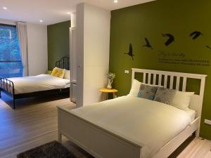 1 dormitorio con cama y pared verde en 忘憂天空民宿 en T'an-nan