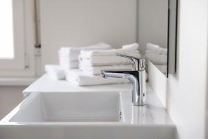 a bathroom sink with a faucet and stacks of towels at Italyescapes Maia in Merano